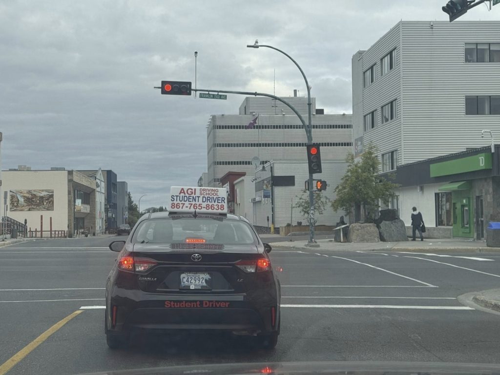 agi-driving-student-driver-car-at-traffic-light-in-city-2023